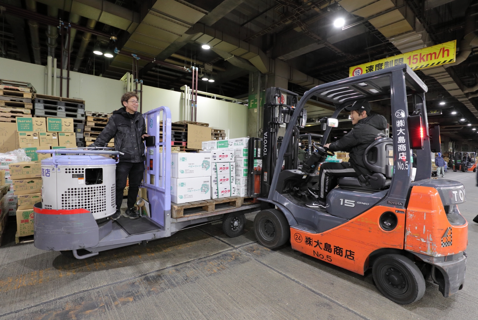 商品を機材で運ぶ男性2名