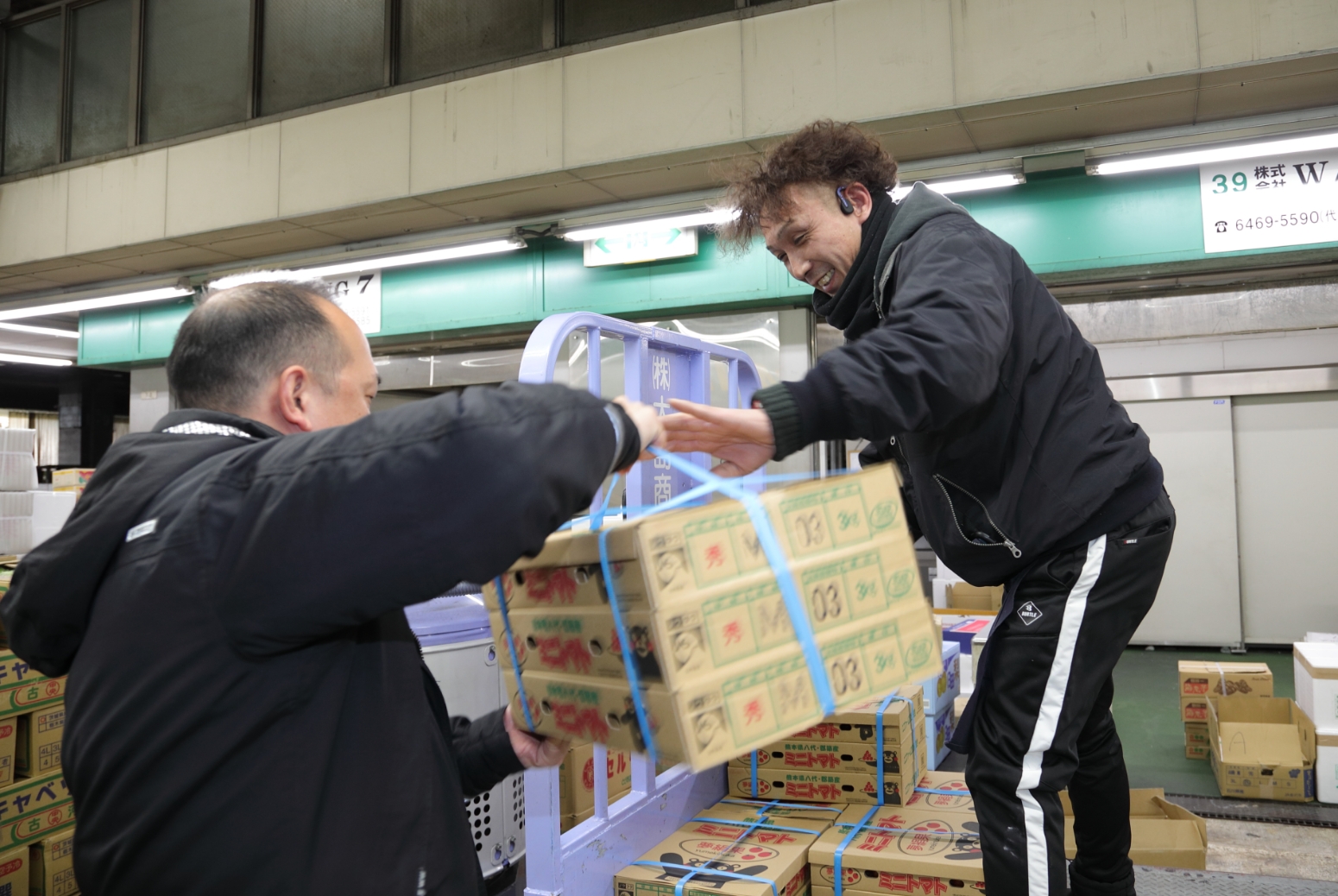 商品を受け渡す男性2名